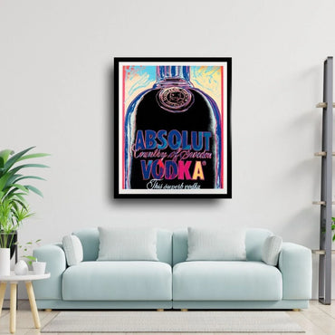 Framed Absolut Vodka poster on a wall above a light blue sofa.