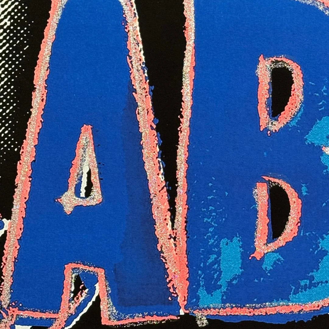 Close-up of blue and pink text with a textured border on a black background