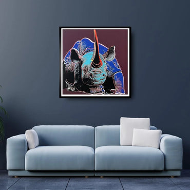 Framed artwork of a rhinoceros on a dark wall above a light blue sofa.