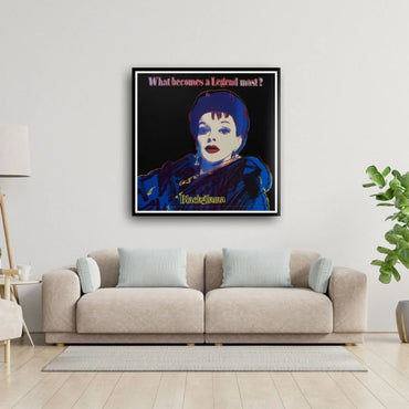 Framed artwork of a stylized portrait on a wall above a beige sofa in a living room.