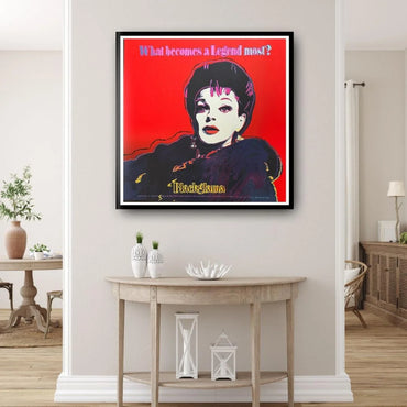 Framed artwork of a stylized portrait with a red background in a living room setting.