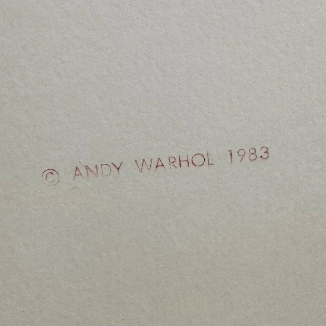 Signature and year '1983' by Andy Warhol on a textured beige background