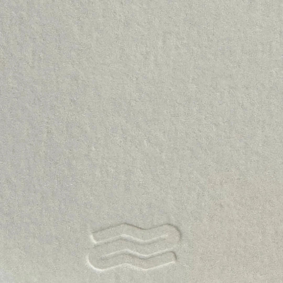Close-up of a textured light gray surface with subtle patterns.