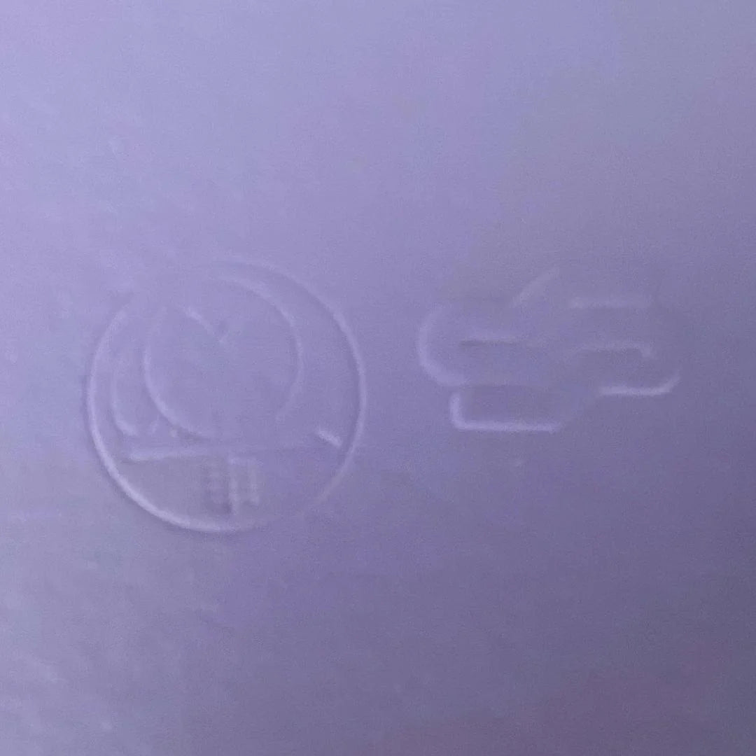 Close-up of a textured purple surface with embossed symbols.