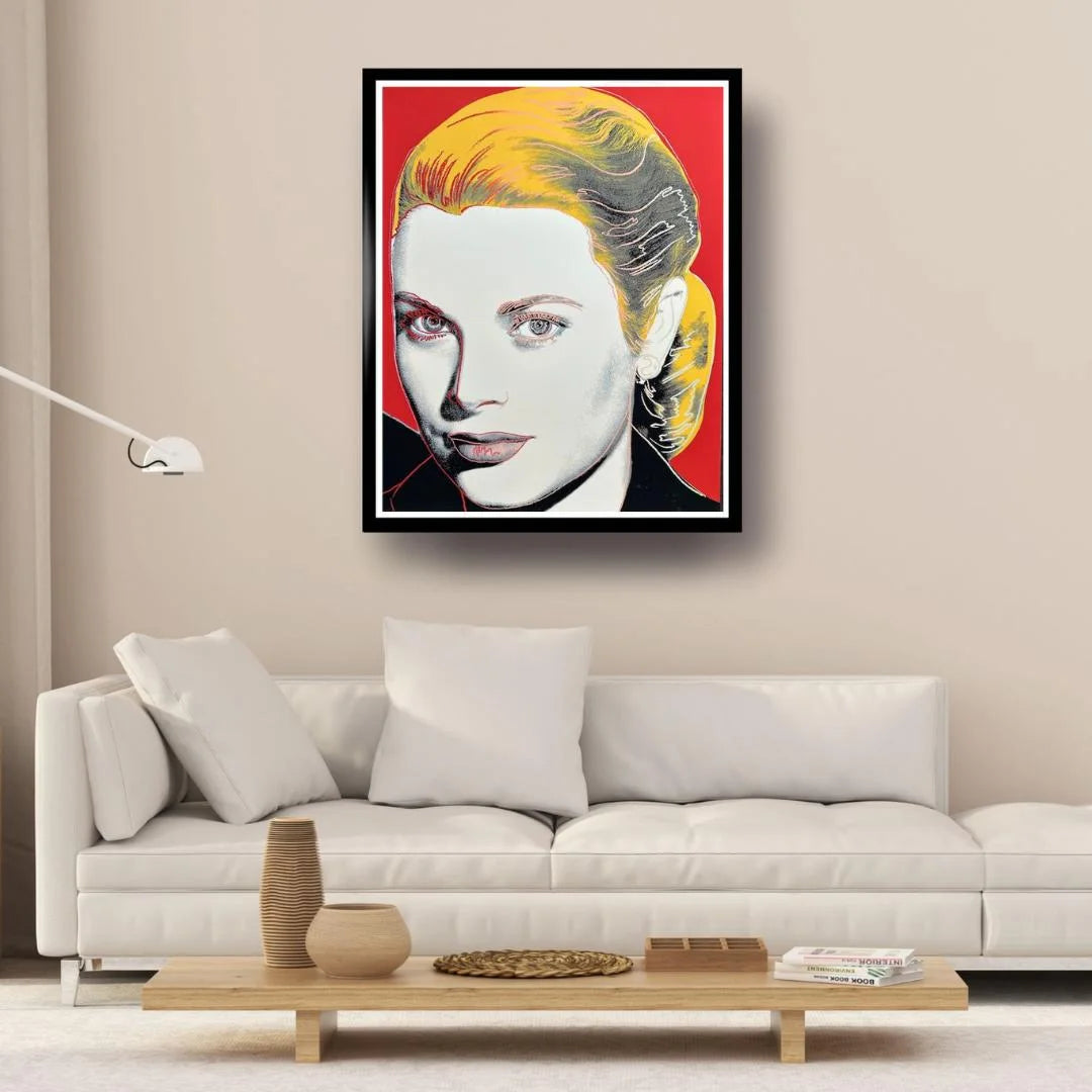 Framed artwork of a stylized portrait on a wall above a white sofa in a living room.