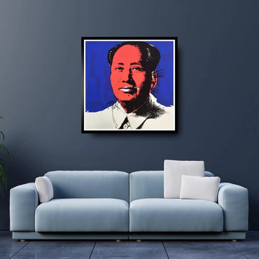 Framed artwork of a portrait on a dark blue wall above a light blue sofa.
