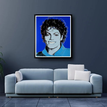 Framed portrait of a famous person above a light blue sofa in a room with dark walls.