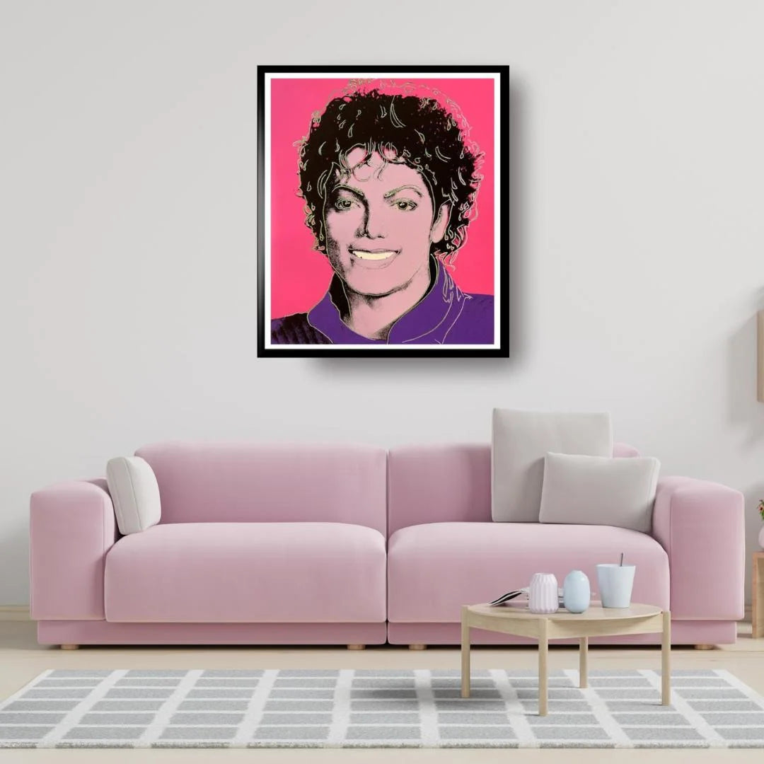 Framed portrait of Michael Jackson on a wall above a pink sofa in a living room.