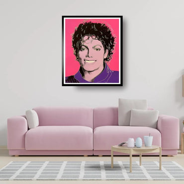 Framed portrait of Michael Jackson on a wall above a pink sofa in a living room.
