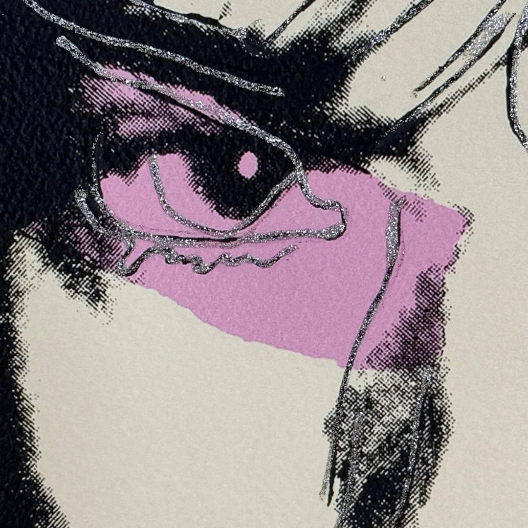 Close-up of a stylized eye with purple sclera and black pupils on a beige background.