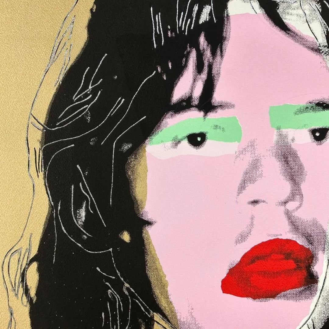 Artistic depiction of Mick Jagger's face with red lips and green eyeshadow on a gold background with diamond dust.