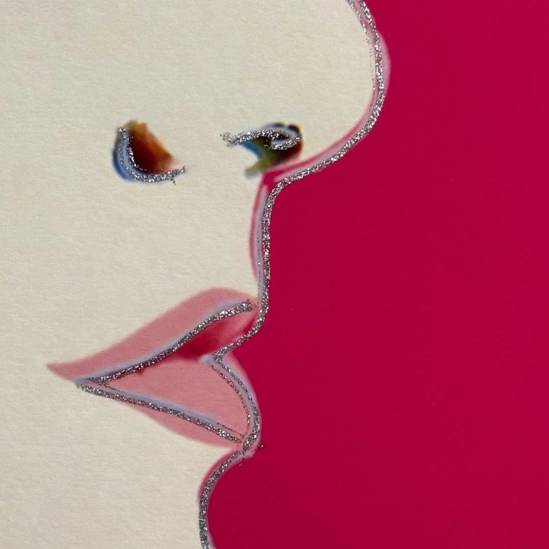 Close-up of a stylized face with glittery diamond dust on a pink background