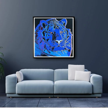 Blue tiger artwork on a dark wall above a light blue sofa with white cushions.
