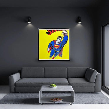 Superman Warhol print on a dark wall above a gray sofa in a modern man cave.
