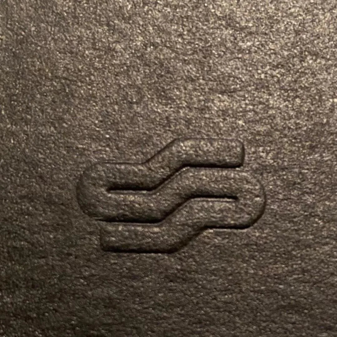 Close-up of a textured brown surface with an embossed logo.