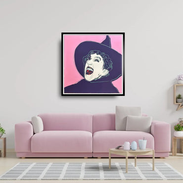Framed artwork of the Wicked Witch on a pink background above a pink sofa in a living room.