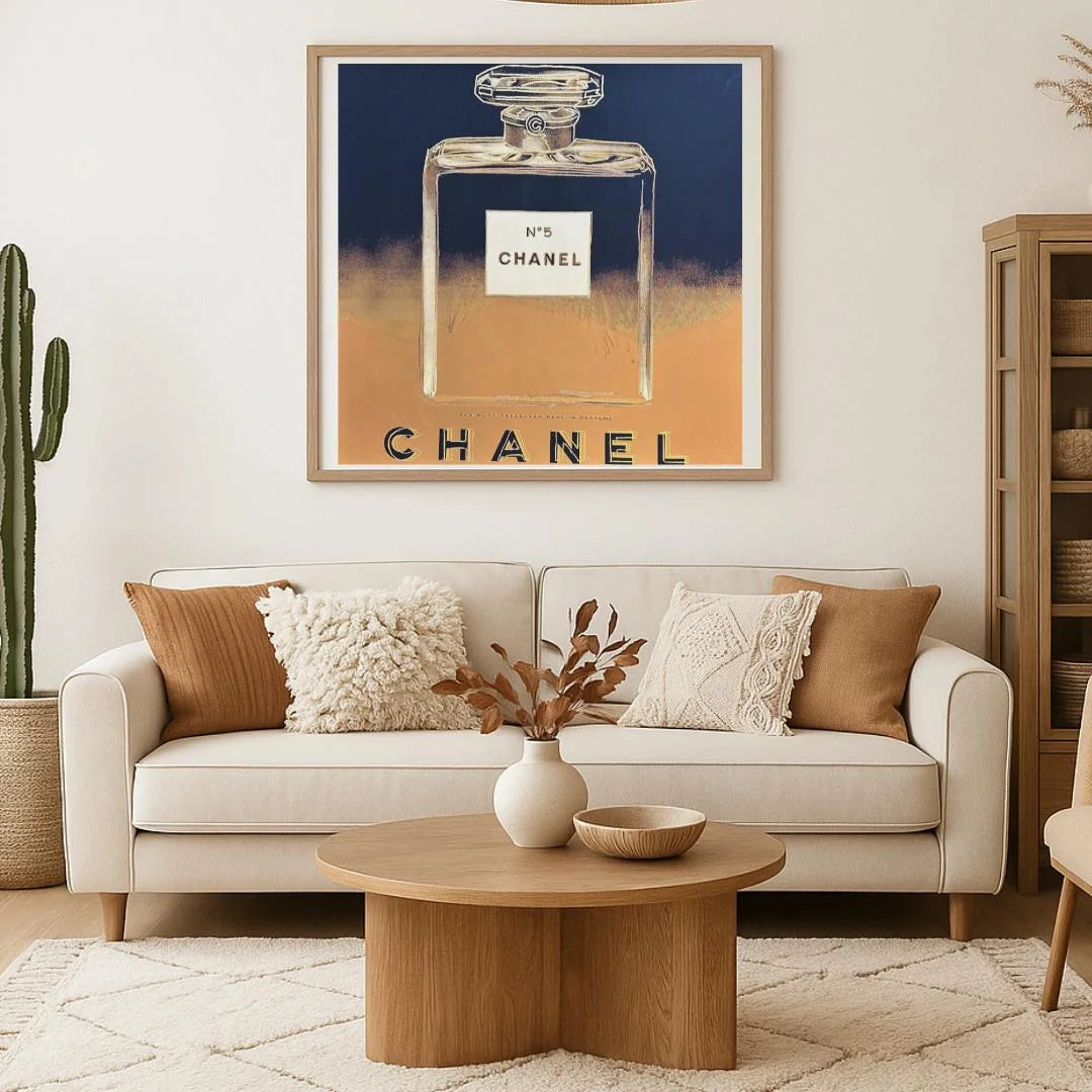 Living room with a Chanel perfume bottle artwork on the wall above a beige sofa.