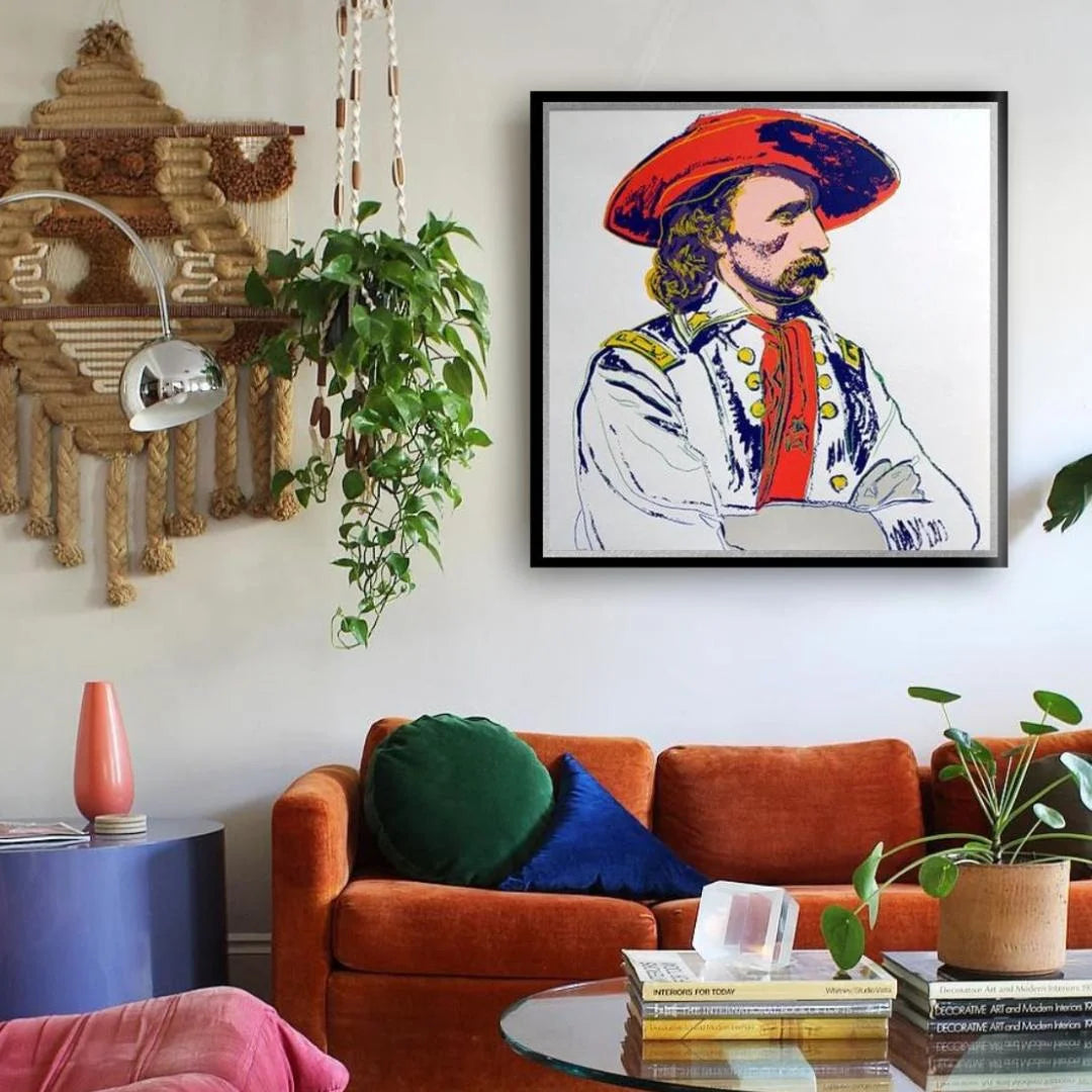 Living room with a colorful framed portrait on the wall, orange sofa, and decorative items.