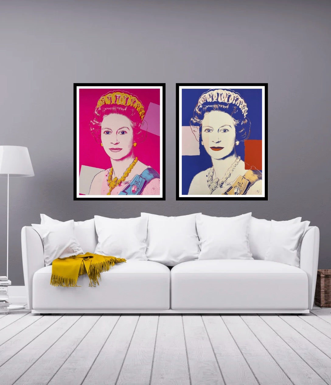 Two framed portraits on a wall above a white sofa with a yellow blanket.