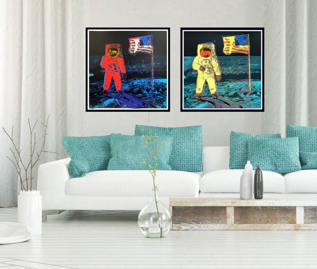 Living room with a white sofa, teal pillows, and two framed artworks of astronauts on the moon.