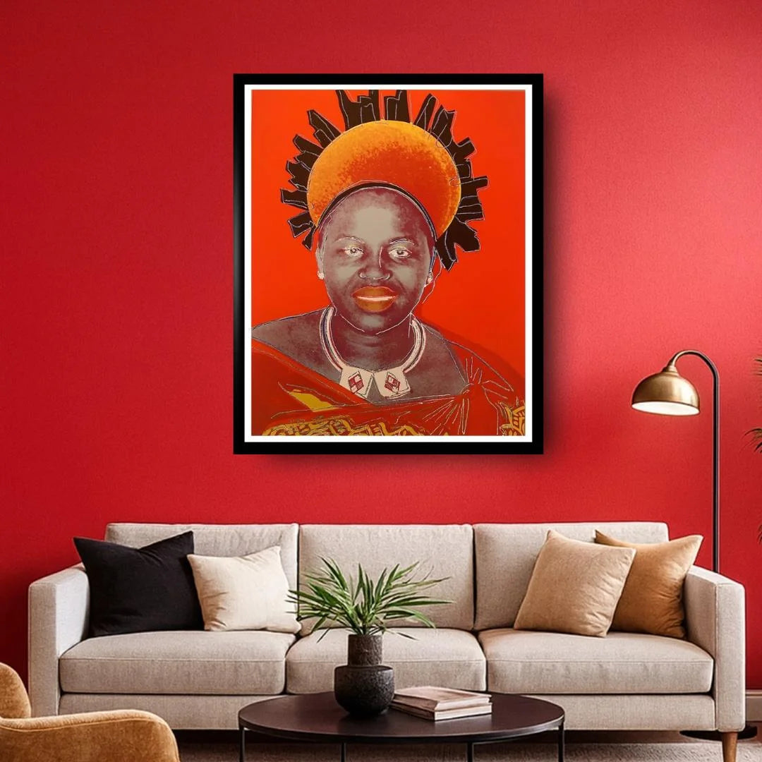 Framed artwork of a person with a headdress on a red wall above a beige sofa.
