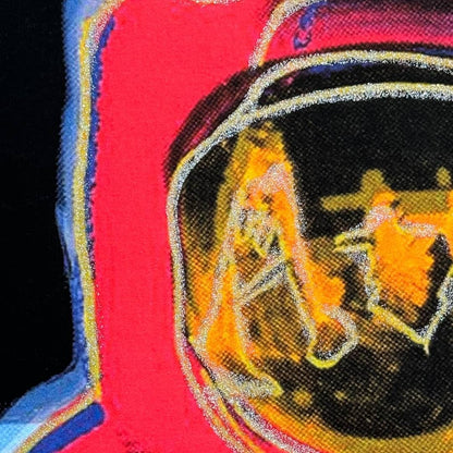 Close-up of a colorful fabric patch with an astronaut design on a red background