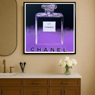 Framed Chanel perfume bottle artwork on a wall above a bathroom vanity.