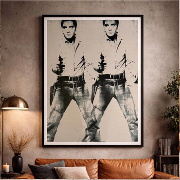 Framed artwork of a stylized portrait on a wall above a sofa.