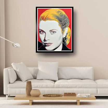 Framed artwork of a stylized portrait on a wall above a white sofa in a living room.