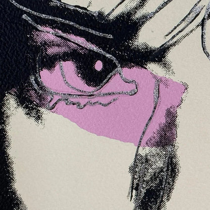 Close-up of a stylized eye with purple sclera and black pupils on a beige background.