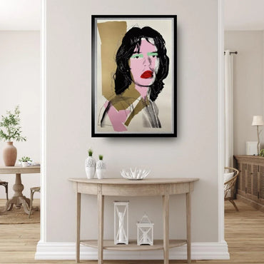 Framed artwork of a stylized portrait on a wall in a room with a table and decor items.