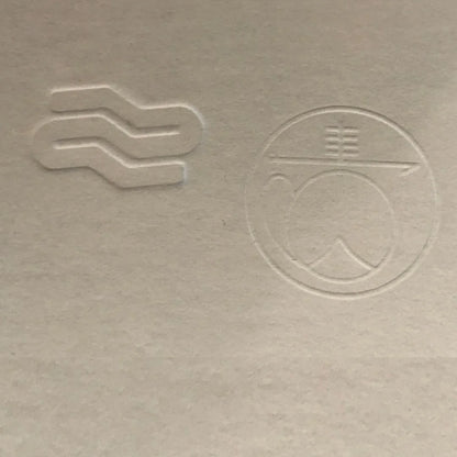 Two embossed symbols on a textured beige surface