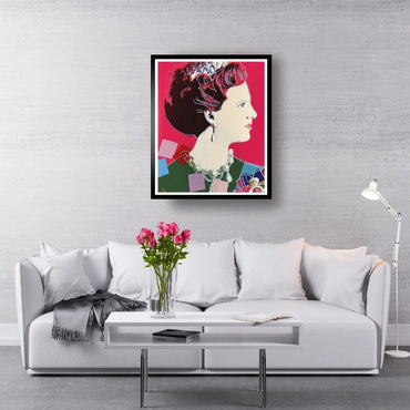 Framed artwork of a woman's profile on a gray wall above a white sofa with pink flowers.