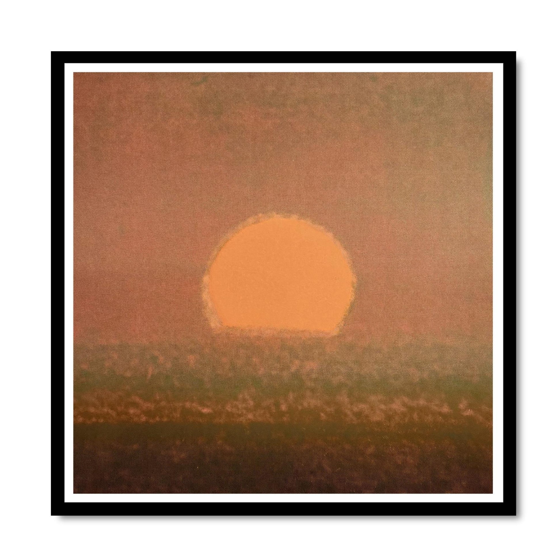 Framed artwork of a sunset with a large orange sun over a field.