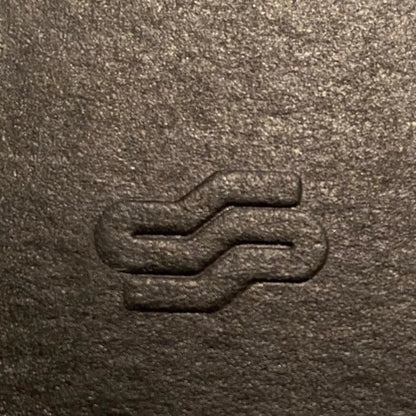 Close-up of a textured brown surface with an embossed logo.