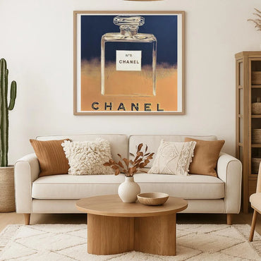 Living room with a Chanel perfume bottle artwork on the wall above a beige sofa.