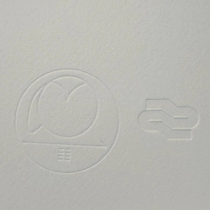 Gray textured surface with embossed circular design and number '2'