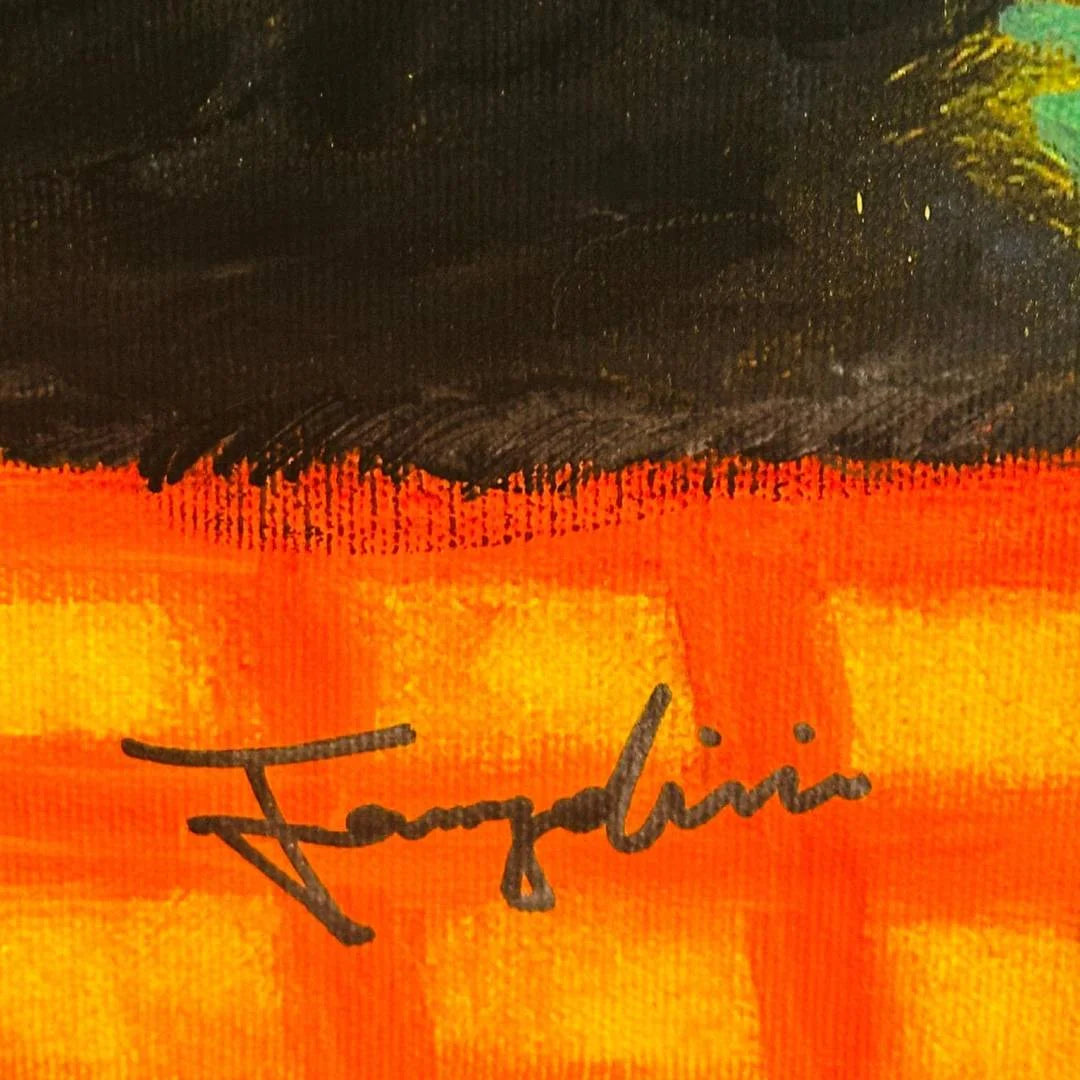 Close-up of a colorful fabric with a signature on an orange and black background
