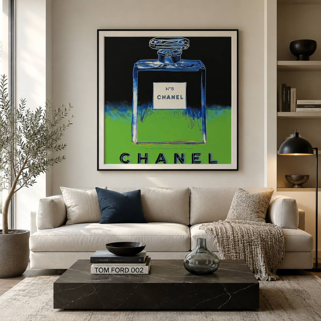 Modern living room with a Chanel perfume bottle artwork on the wall above a beige sofa.