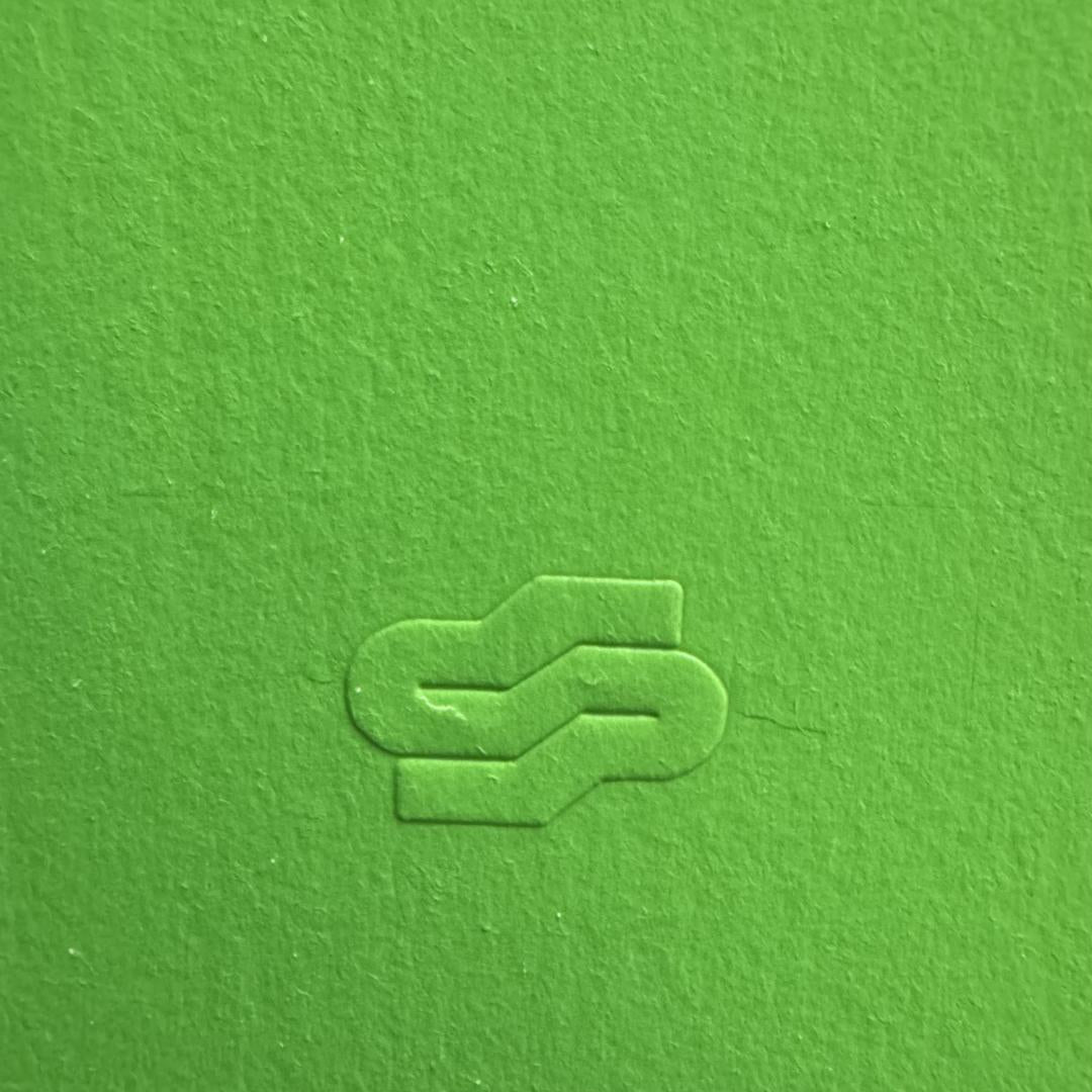 Green textured surface with a logo embossed in the center