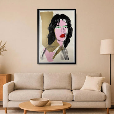 Framed abstract art of Mick Jagger's face on a beige wall above a beige sofa.