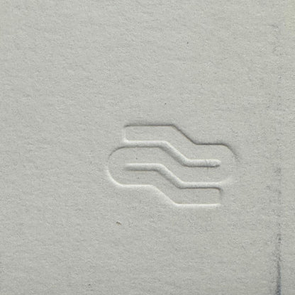Close-up of a textured gray surface with a subtle logo or symbol.