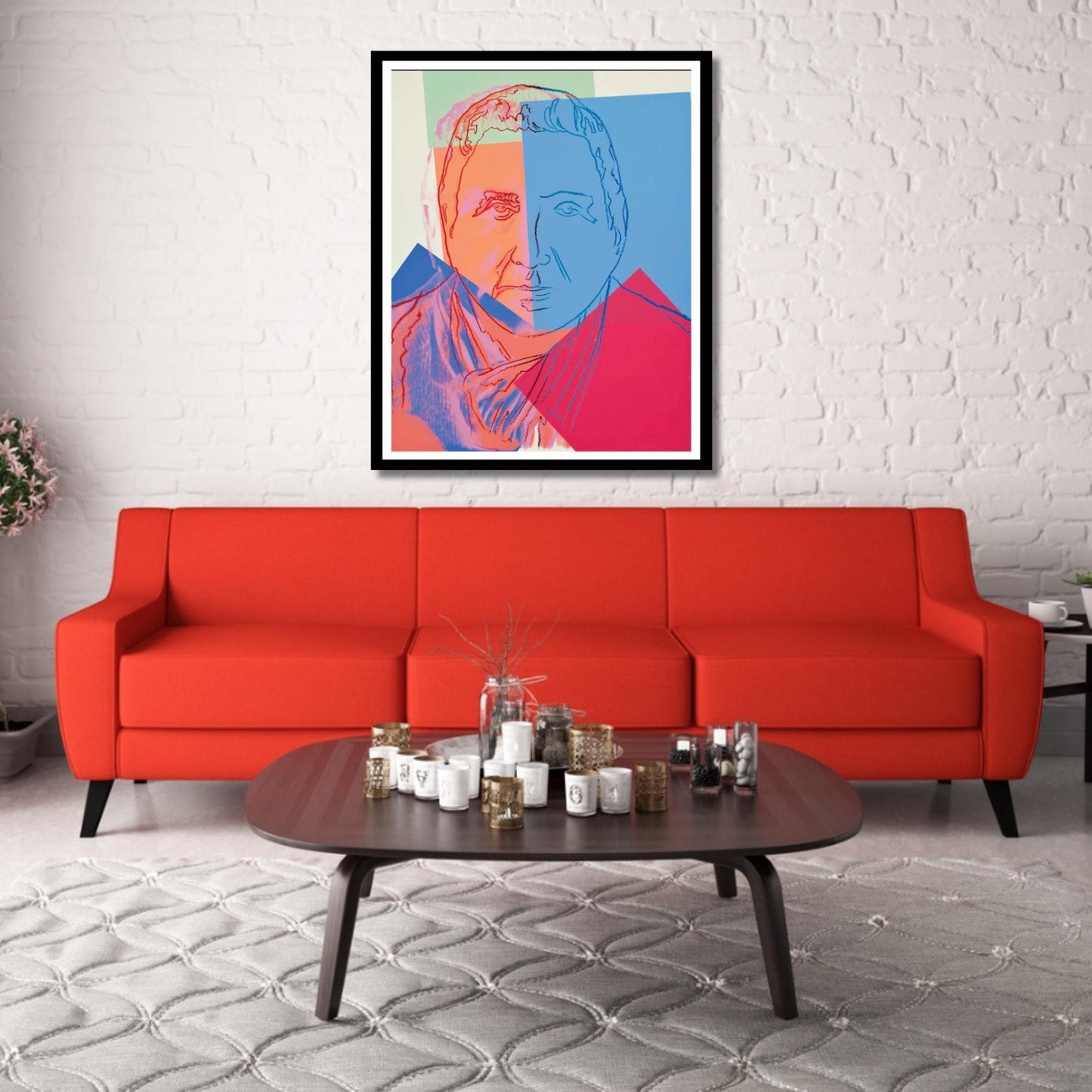Modern living room with a red sofa, coffee table, and colorful abstract art on a white brick wall.
